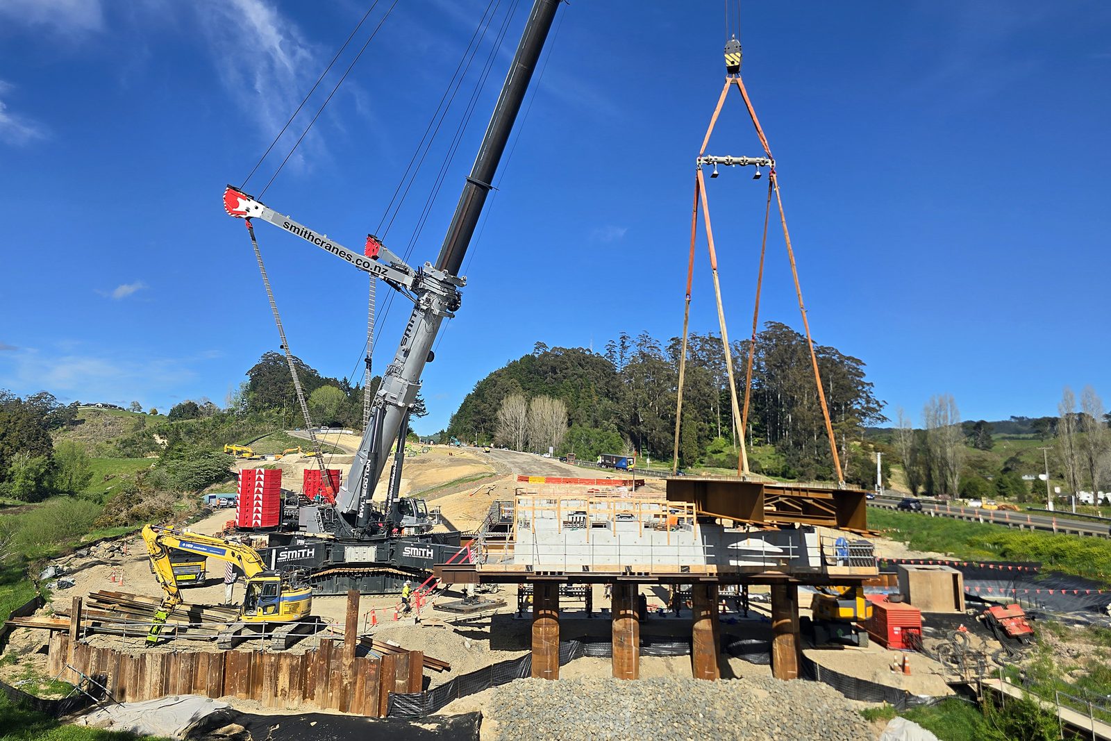 The first section of steel beams being lifted onto the pier by a 1200 tonne telescopic crawler crane. 9 October 2026. SH29 Omanawa Bridge Replacement