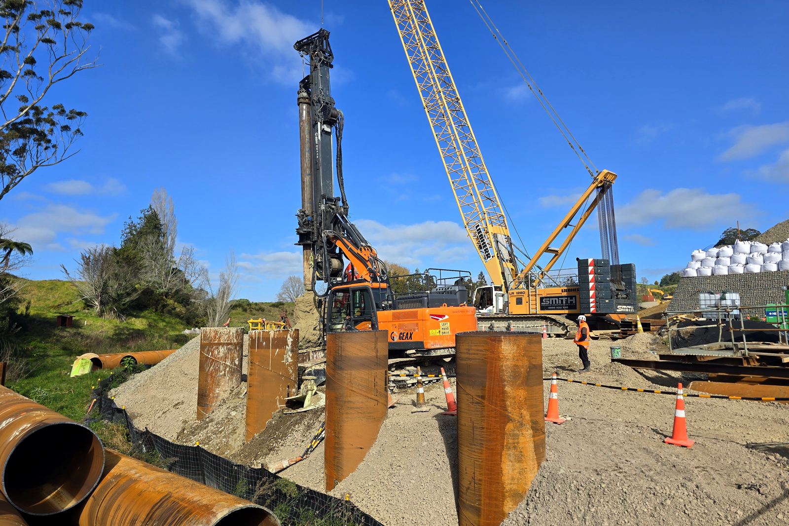 Piling rig and casing on the river flat. July 2026. SH29 Omanawa Bridge Replacement